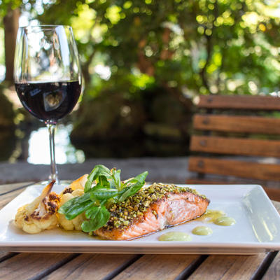 Grilled fish with decorations, glass of red wine on the side