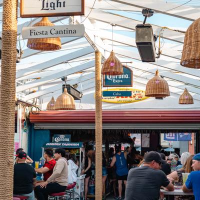 Guests dining on open air patio with wicker lighting