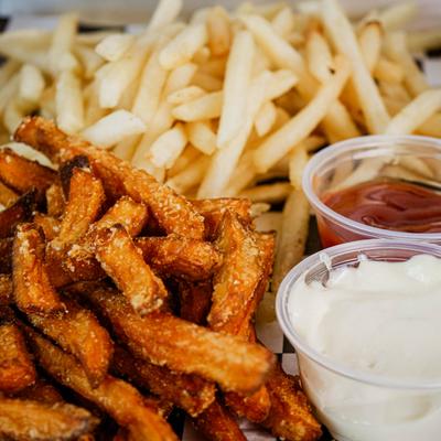 Sweet potato fries and regular fires with ketchup and mayo on the side.