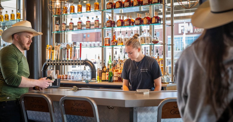 Interior, full bar with a bartender and a guest at a bar counter