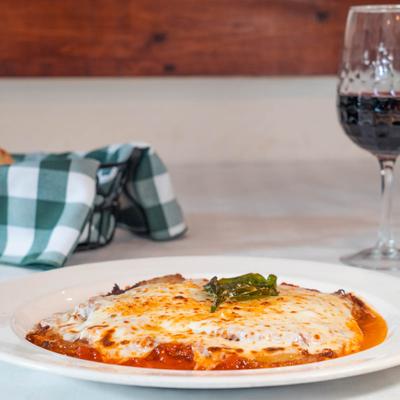 Baked eggplant with mozzarella cheese and tomato sauce, served with red wine.
