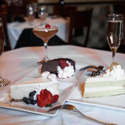 multiple cake desserts and drinks in backround.