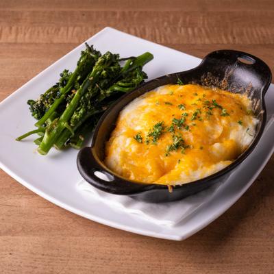 Shepherd's pie served in a cast-iron skillet, paired with broccoli.