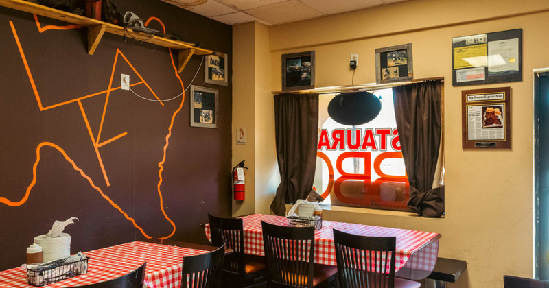 Interior, tables and chairs, big window, framed photos on the wall
