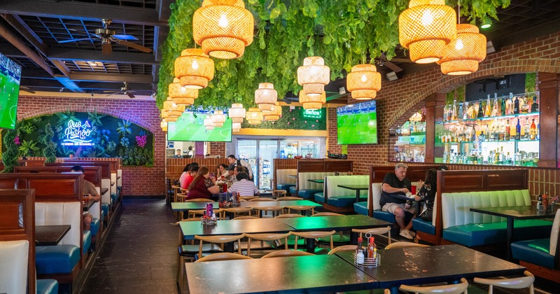 Interior, seating area with tables and chairs, chandeliers and plants from the ceiling