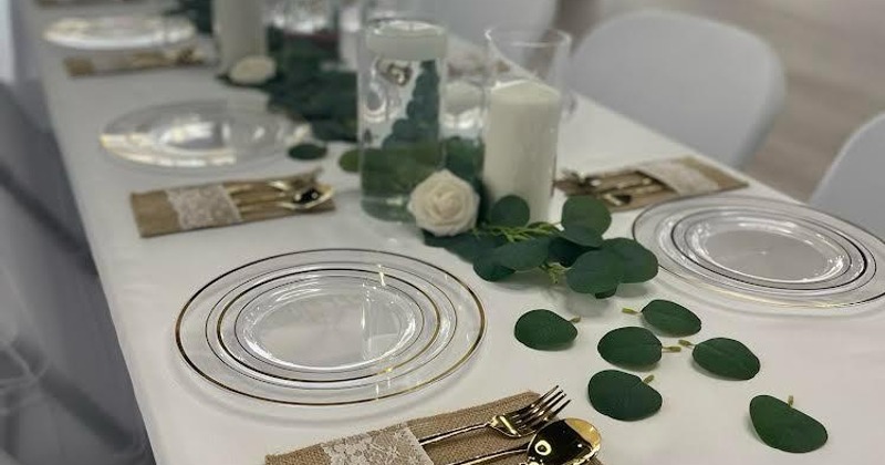 A decorated dining table set with  glass plates and shining silverware