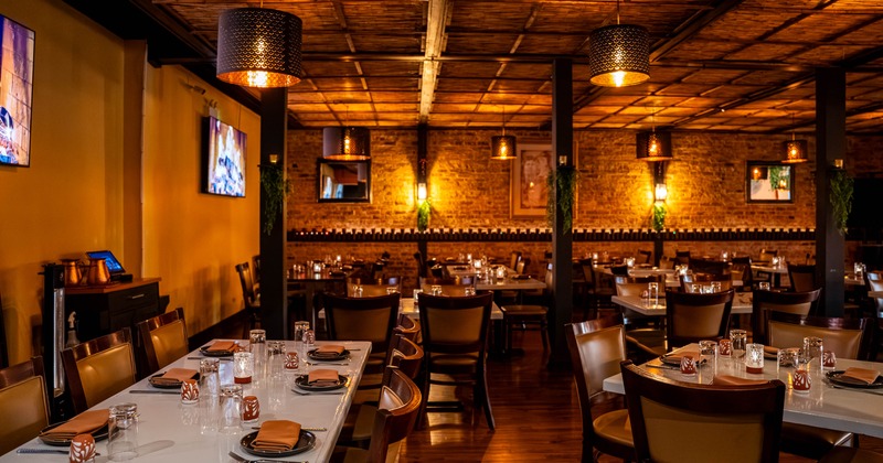 Interior seating area with bamboo ceiling, warm lighting, set tables and chairs