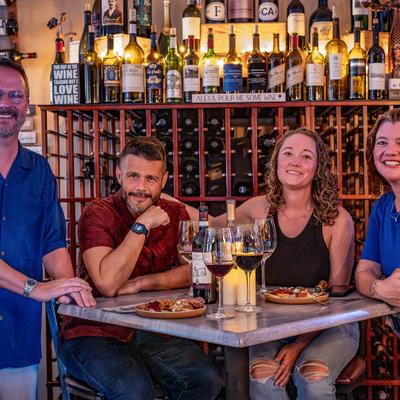 People gathered around a table with wine.