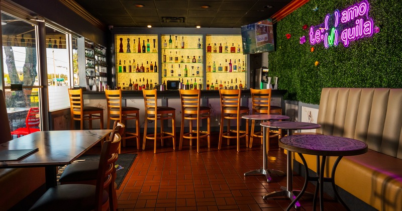 Bar area, tables, bar, drink rack behind