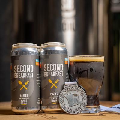 Cans and a glass of Second Breakfast Porter, with silver medal in the foreground.