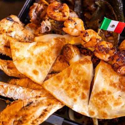 Mix platter with various grilled meats, shrimp skewers and quesadillas.