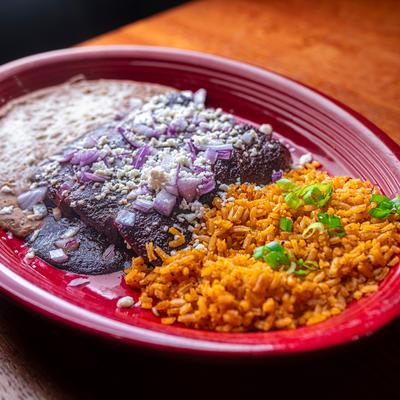 Mole enchilada, sides of rice and refried beans.