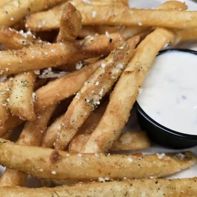 Parmesan truffle fries with a cup of dipping sauce.