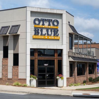 Storefront with gray brick facade, entrance and signage.