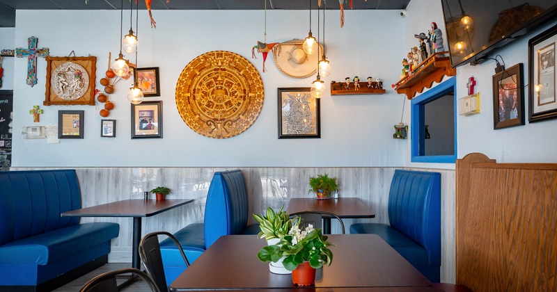 Colorfully decorated  interior - blue booths, wooden tables, hanging pendant lights, folk art.