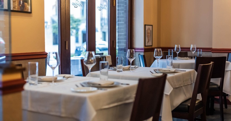 Interior, dining area, close up on dining tables by the patio doors, ready for guests