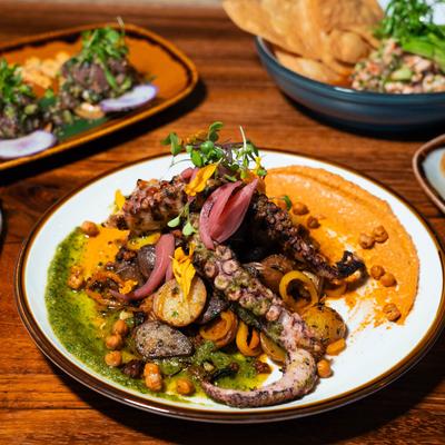 Charred Octopus, with pistachio pesto, romesco, potatoes, herbs, and spices.