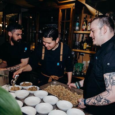 Kitchen staff filling bowls with fried rice.