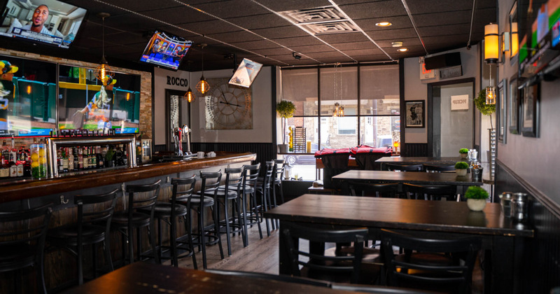 Bar Area - flat screen TVs, bar counter, shelves with drinks and glasses