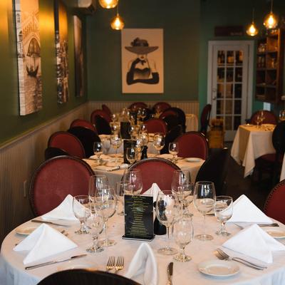 Dining room with elegantly set tables and wall art.