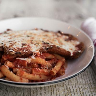 Chicken Parmigiana with rigatoni and tomato sauce.