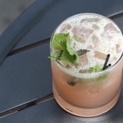 Pink translucent cocktail with mint leaves and ice