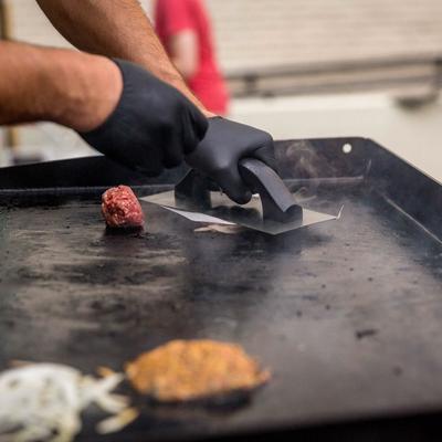 Working grill, employees' hands grilling burgers