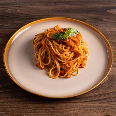 Spaghetti marinara served on a round plate with a yellow rim.