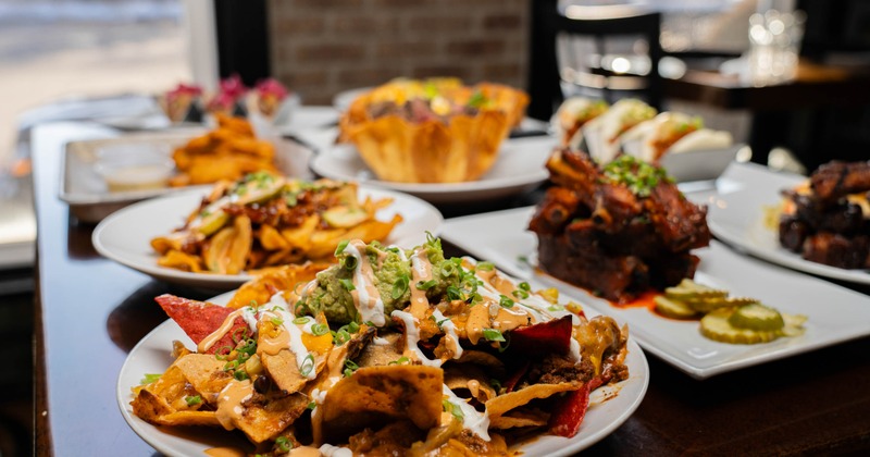 Loaded nachos platter served on the table alongside other menu items