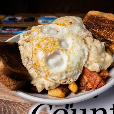 Fried eggs, toast, deep fried home fries, bacon, sausage gravy, and toast.