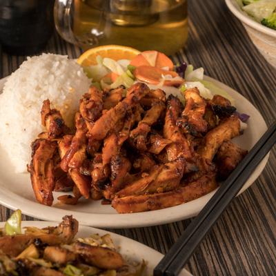 Spicy chicken with sides of rice and salad.