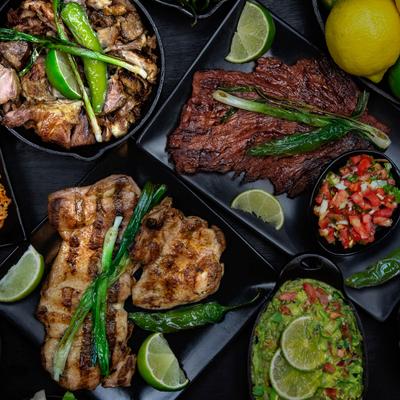 Various grilled meats, salsa, and guacamole.