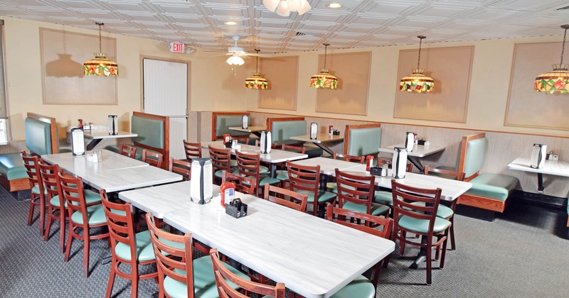 Interior, dining area, tables for six, seating booths with tables in the back, carpet flooring
