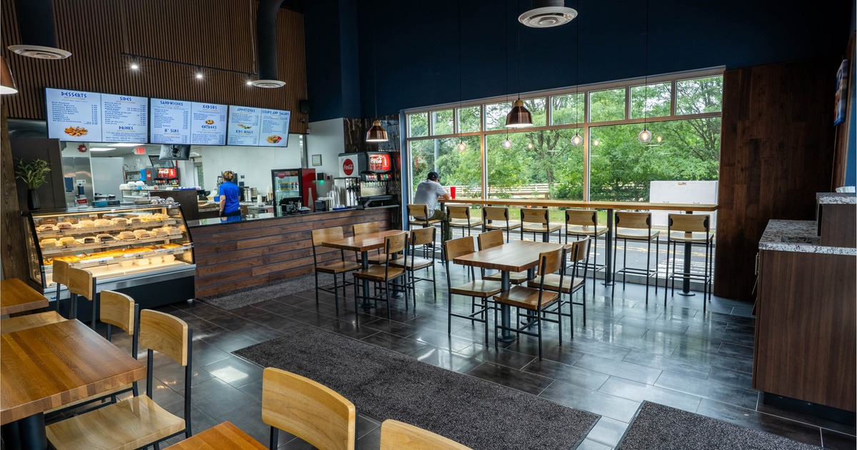 Interior, seating area, wooden top tables with chairs, high seating area in the back