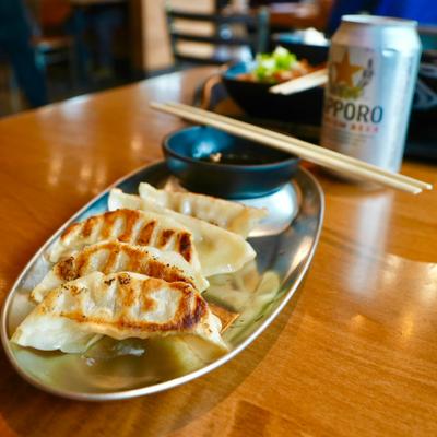 Plate of fried dumplings served with a dipping sauce.
