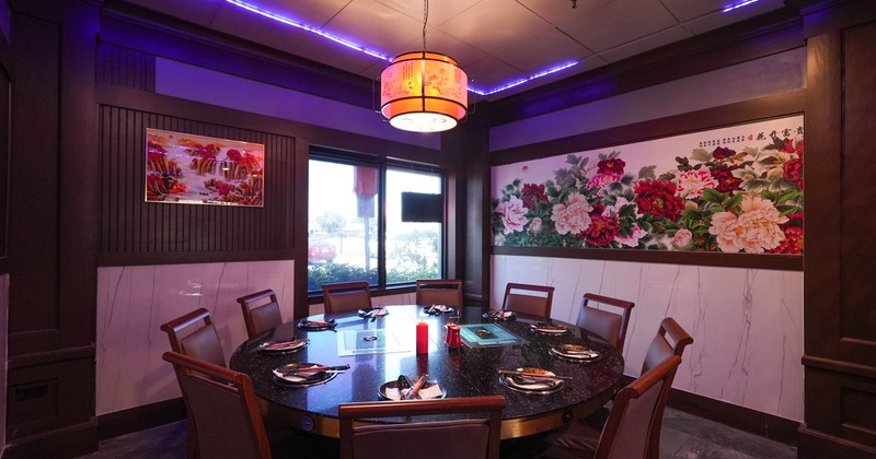 Interior, private dining room, round black marble top table for ten, ready for guests