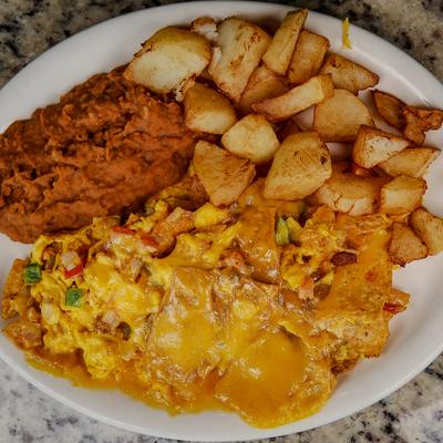 Scrambled eggs with melted cheese, beans, and breakfast potatoes.
