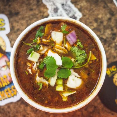 Mexican soup topped with onions, cilantro, and herbs.