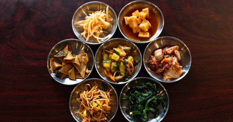 Variety of Korean side dishes, such as  kimchi, seasoned spinach, banchan, and other