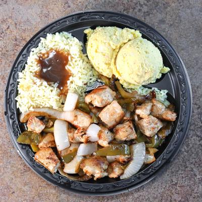 Marinated Chicken Tips, with grilled peppers, onions, rice with gravy, and potato salad.
