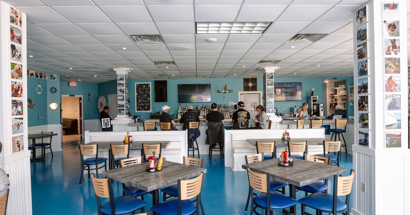 People seated at the bar of a casual restaurant with blue floors