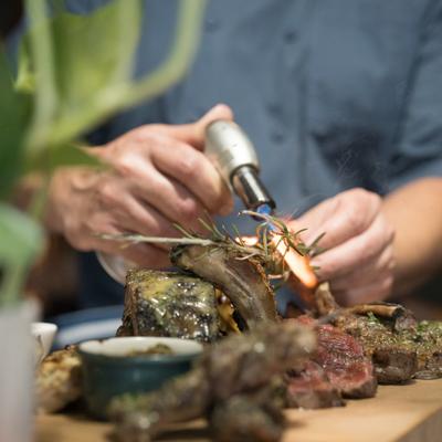 Meal preparing, flame on rosemary and meat