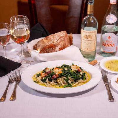Tagliatelle with Shrimp Broccoli Rabe, served with bread and wine.