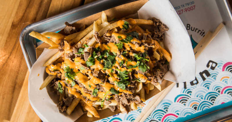 Sliced meat, fries, dip and green decorations