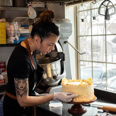 Staff member decorating a cake