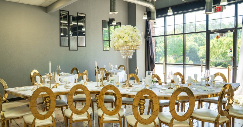 Elegant dining setup with a large table, gold chairs, and a white floral