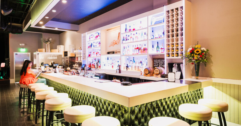 Modern bar with plush seating and illuminated bottle displays