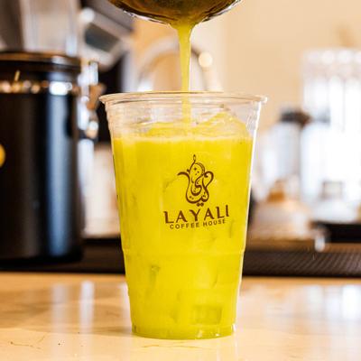 A drink being poured in a plastic cup.