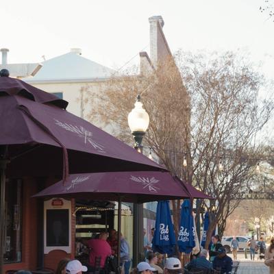 Outdoor seating area with umbrellas and street view.