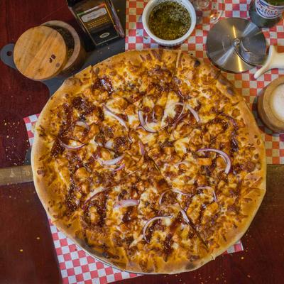 BBQ chicken pizza topped with bacon and red onions.